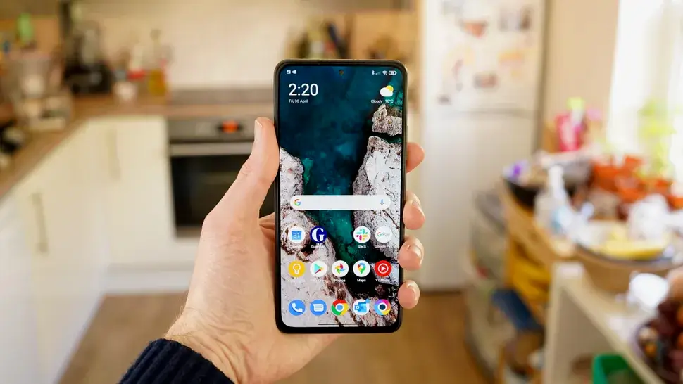The Poco F3 being held in the hand.