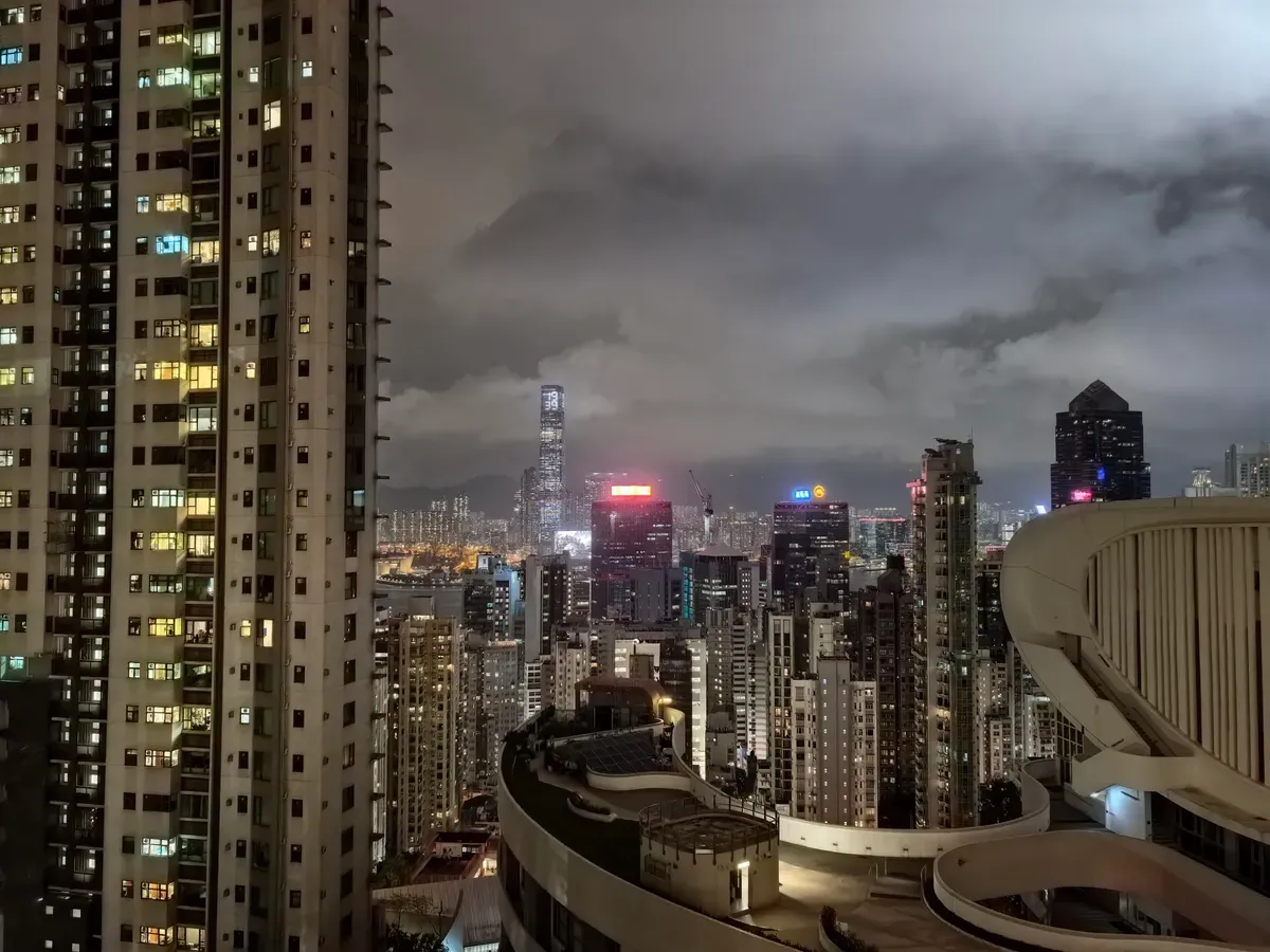 با تنظیمات پیش‌فرض گرفته شده (۱x). به یک تابلوی قرمز بالای ساختمان در دوردست توجه کنید.